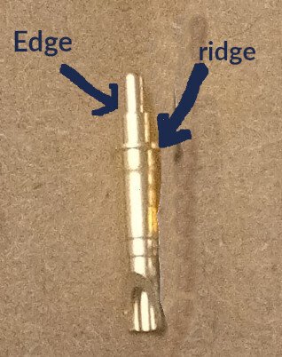 Photo of a pogo pin with text defining the "edge" and "ridge" of the component