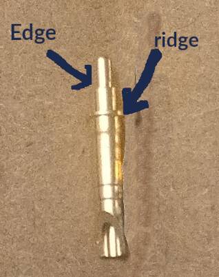 Photo of a pogo pin with text defining the "edge" and "ridge" of the component